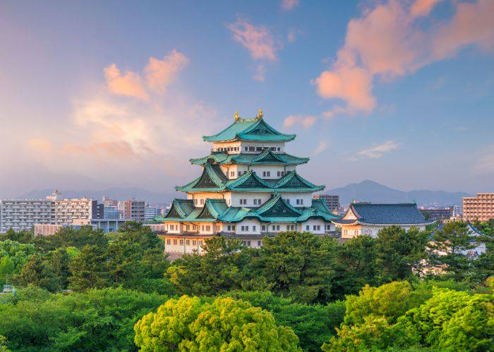 A scenic shot of Nagoya Castle rising above green trees in Nagoya.